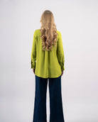 Chemise fluide femme vert lime avec col classique et boutons apparents portée avec jean large-vue de dos