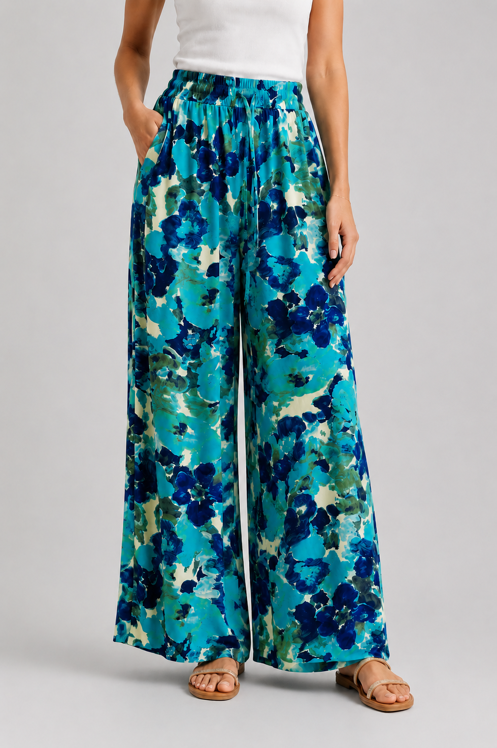 Pantalon large femme à imprimé floral bleu turquoise porté avec débardeur blanc sur fond gris-VUE DE FACE