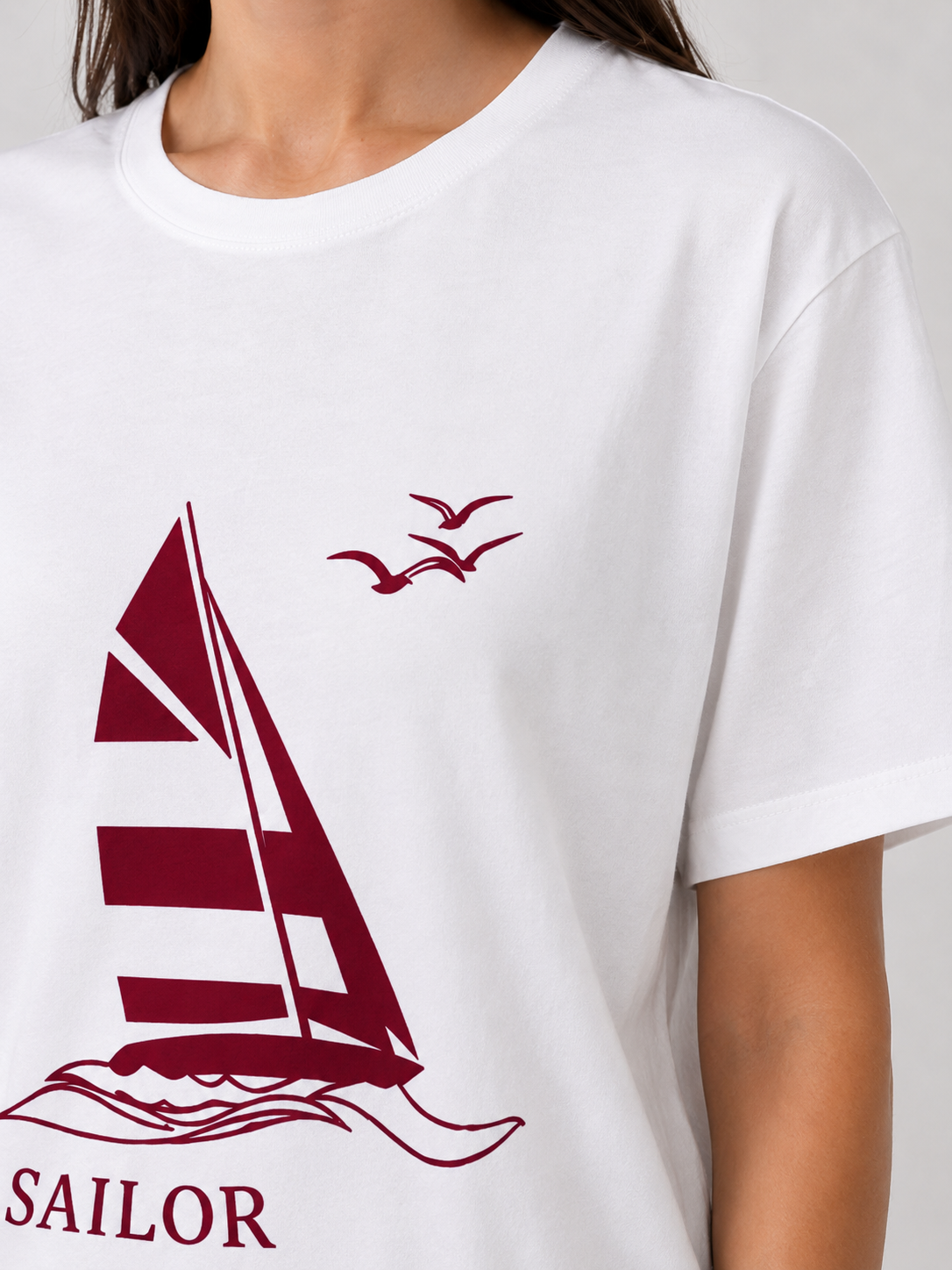Détail porté du t-shirt blanc Sailor avec imprimé bateau bordeaux